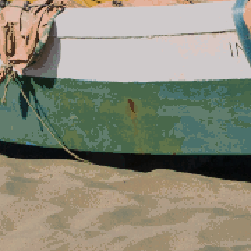 The app's prediction of a fishing boat on a beach with cleanup off: grainy sand and a speckled hull.