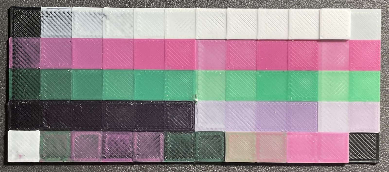 A printed Polychrome calibration card: a row of white patches along the top, a row for each colour in the middle, and mixed patches along the bottom