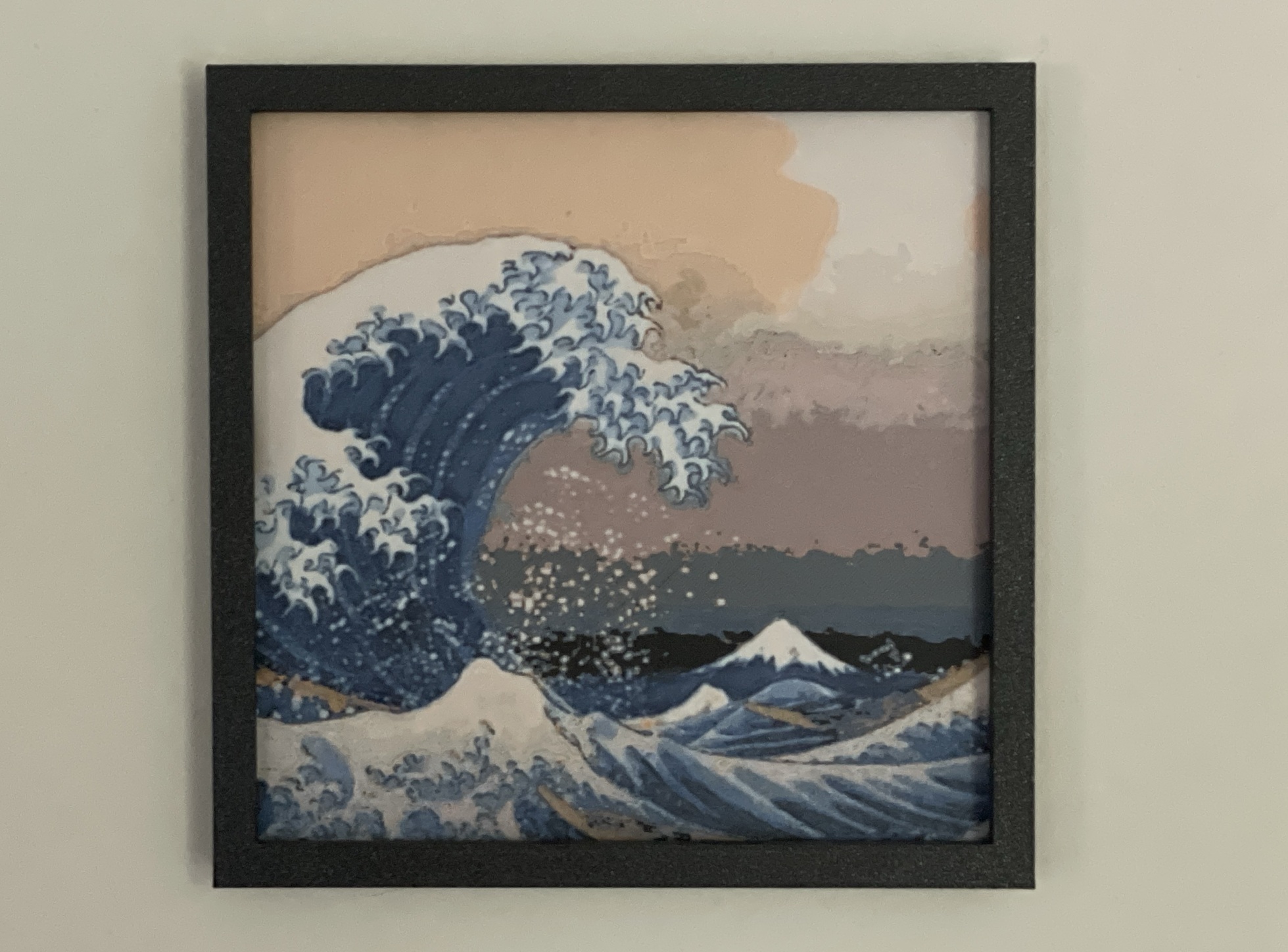 My Polychrome print of The Great Wave in a black frame hanging on a wall