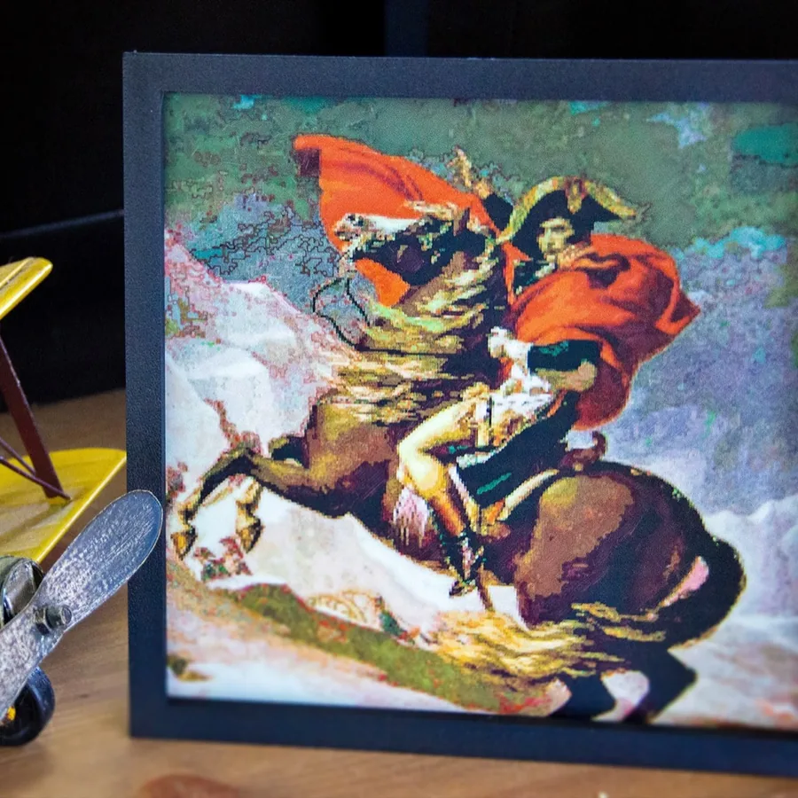 My framed Polychrome print of Napoleon Crossing the Alps beside a model biplane