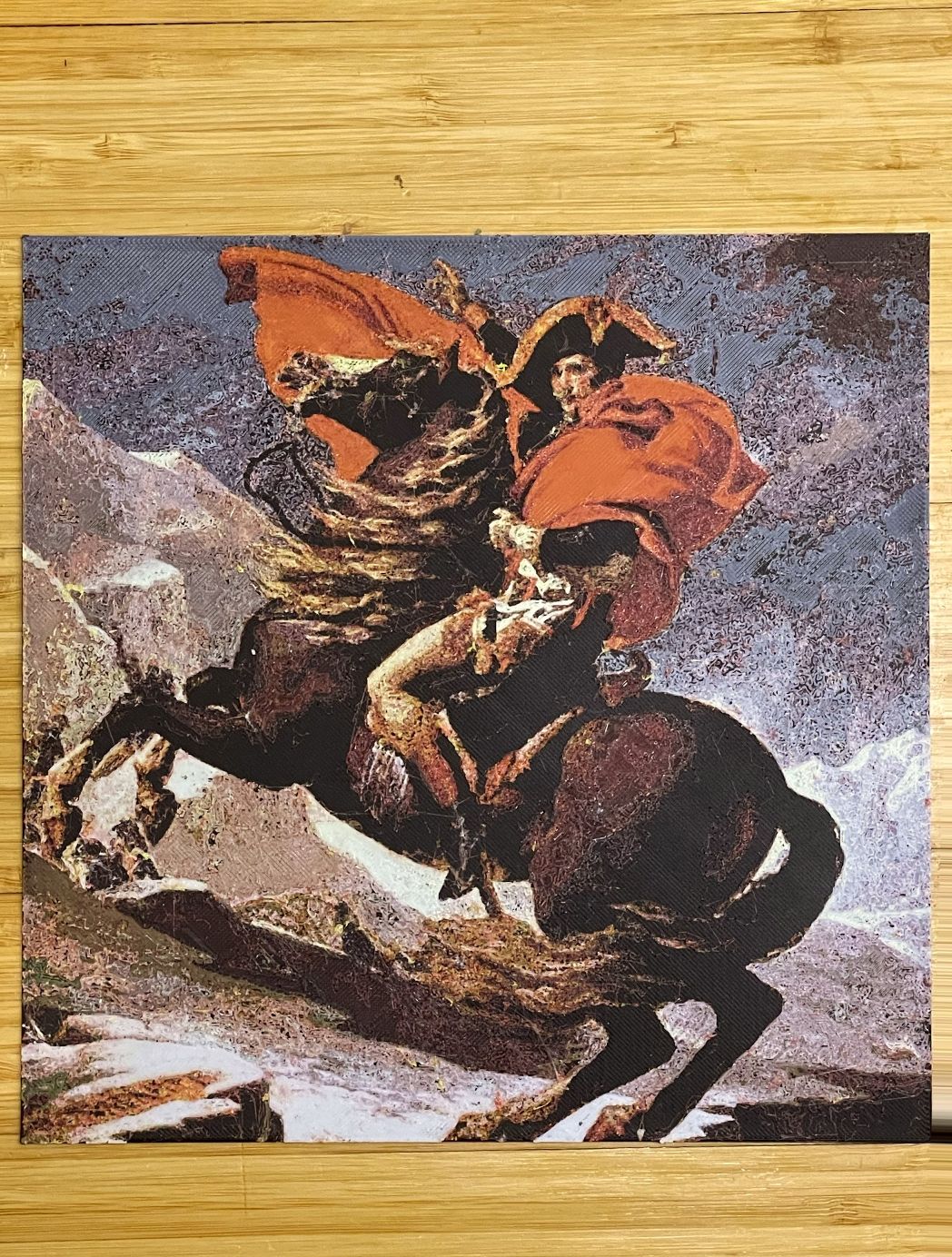 Photo of my Polychrome print of Napoleon Crossing the Alps, lying flat on a bamboo table