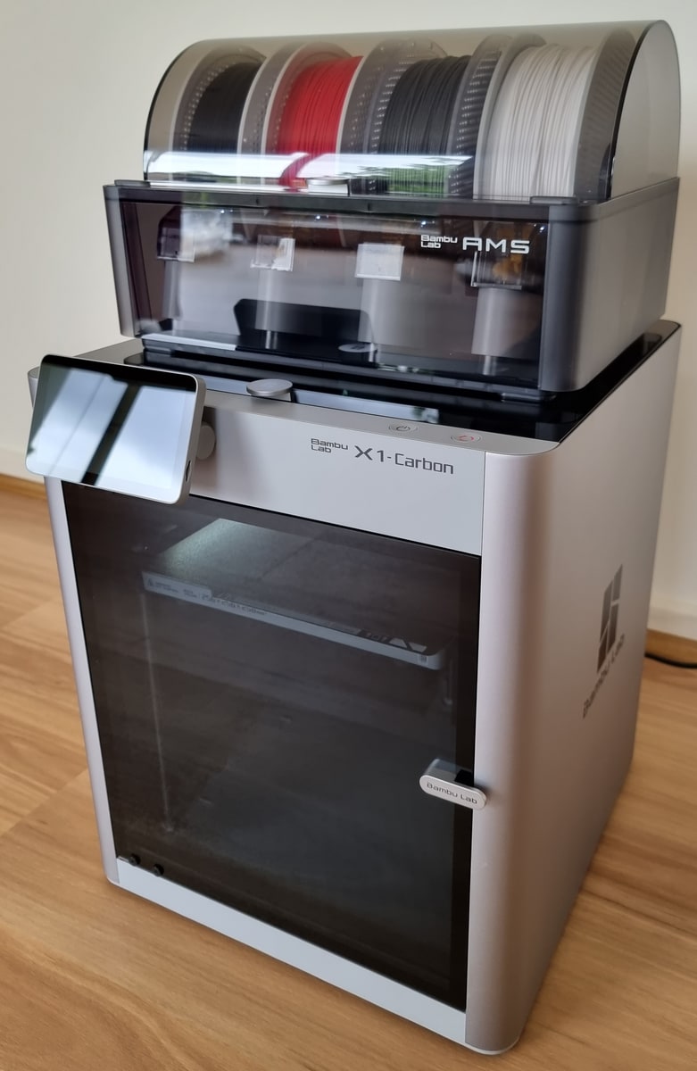 A Bambu Lab X1 Carbon printer with an AMS holding four spools on top